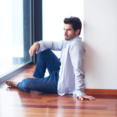 relaxed young man drink first morning coffee at modern home indoors at rainy window drops window